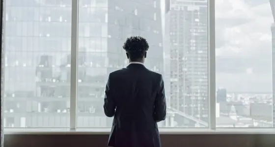 man standing looking out to buildings